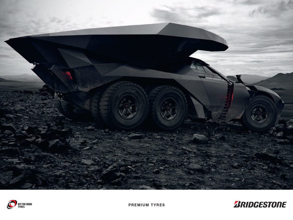 Hybrid car with huge tires moving stones