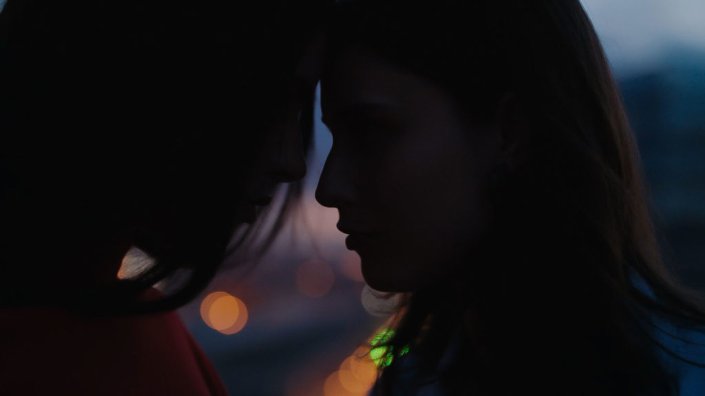 Two girls looking each other with the city in the background